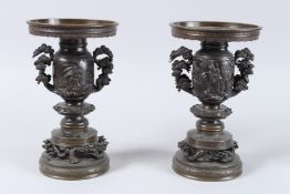 A GOOD PAIR OF 19TH CENTURY JAPANESE BRONZE VASES decorated with figures and gorgon handles. 10ins