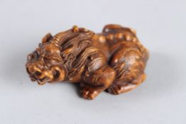 A CARVED WOOD HARDWOOD DRAGON NETSUKE. 3ins long.