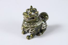 A CHINESE GOOD LUCK FOO DOG, green enamel metal, a pearl in the dog's mouth.