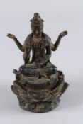 A BRONZE SEATED DEITY with four arms on a lotus leaf. 7ins high.