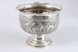 A GOOD BURMESE SILVER PEDESTAL ROSE BOWL, the side repousse with palm trees and figures. 8ins