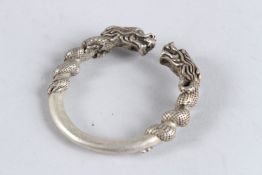 A CHINESE WHITE METAL DRAGON BANGLE.