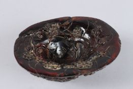 A CHINESE CARVED HORN LIBATION CUP, with almond and other blossom. 7ins diameter.