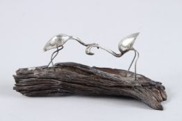 A SILVER GROUP OF TWO FLAMINGOES on a rustic piece of wood. 6.5ins long.