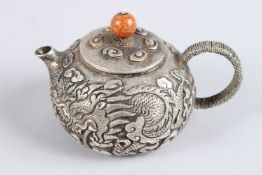 A CHINESE WHITE METAL CARVED DRAGON TEAPOT.