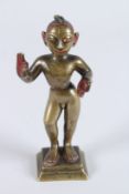 AN INDIAN BRONZE FIGURE OF THE HINDU GOD KRISHNA, on a square base. 7ins high.