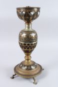 AN ISLAMIC BRASS OIL LAMP with heart shaped decoration. 17ins high.