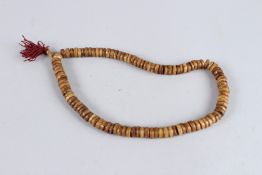 A NECKLACE OF DISC BEADS. 20ins long.
