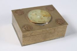 A CHINESE BRASS BOX, the lid with a carved circular jade plaque. Jade 2ins diameter.