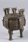 A GOOD ARCHAIC CIRCULAR BRONZE, TWO HANDLE VESSEL AND LID with medallions, on three feet.
