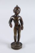 AN INDIAN BRONZE FIGURE OF THE HINDU GOD KRISHNA, on a circular base. 8.5ins high.