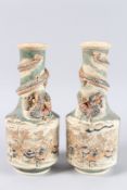 A PAIR OF JAPANESE SATSUMA DRAGON VASES with two large panels of figures and dragons around the