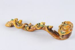A CHINESE BROWN GLAZED PORCELAIN SCEPTRE. 12ins high.