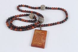 A TIBETAN BUFFALO HORN BEAD CHAIN WITH PENDANT.