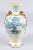 A JAPANESE POTTERY LANDSCAPE VASE with dragon handles. 18ins high.