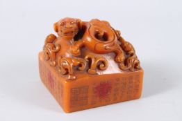A CHINESE CARVED HARDSTONE SQUARE SHAPED SEAL. 11cms wide.
