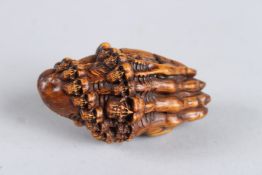 A HARDWOOD HAND AND SKULL NETSUKE. 2.5ins long.