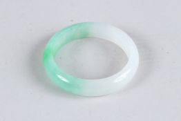 A JADE MOTTLED BANGLE. 3ins diameter.
