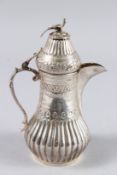 AN ISLAMIC WHITE METAL COFFEE POT, the lid with a bird. 7.5ins high.