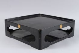 A JAPANESE BLACK LACQUER TWO TIER STAND. 1ft 1ins square x 4ins high.