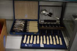 Three cased sets of cutlery.