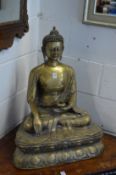 A large cast brass model of a seated Buddha.