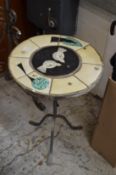 A handmade tile top and wrought iron tripod table.