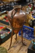 A copper vessel on stand.