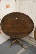 A 19th century carved oak tilt-top tripod table.