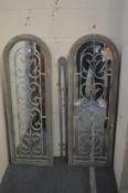 A pair of decorative exterior arched top mirrors with wrought iron decoration.