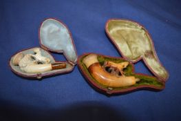 Two cased meerschaum pipes.