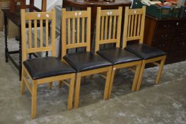 A set of four modern dining chairs.