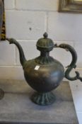 A large heavy cast metal ewer with engraved decoration.