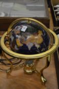 Hard stone inlaid globe on brass stand.