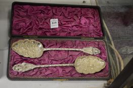 A cased pair of white metal berry spoons.