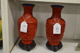 A pair of modern Chinese cinnabar lacquer vases on stands.