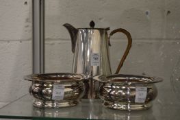 A pair of plated bottle coasters and a plated hot water jug.