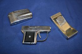 A pistol shaped lighter and two others.
