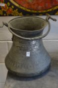 A large Eastern engraved metal vessel with swing handle.