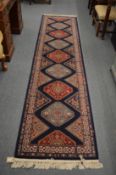 A machine made Persian style runner, blue ground with stylised decoration, 330cm x 80cm.