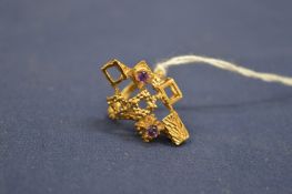 An unusual stylish yellow metal and amethyst ring.