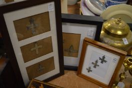 A group of bronze crosses, mounted and framed.