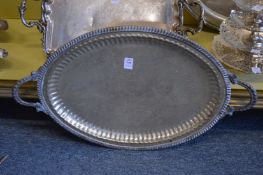 A large oval twin handled silver plated tray with engraved decoration.