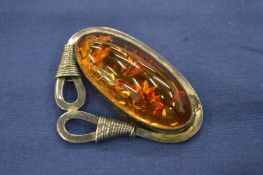 A silver and amber brooch.