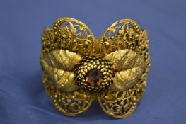 A decorative cuff style floral shaped bangle.