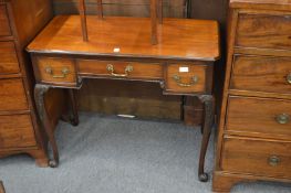 A mahogany lowboy with carved cabriole legs.