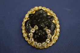 A decorative lion mask brooch.