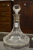 A glass port decanter with silver collar.
