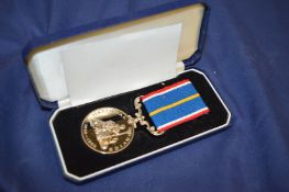 A cased National Service medal.