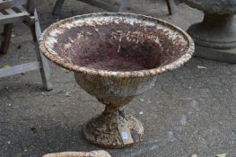 An old weathered cast iron pedestal urn.